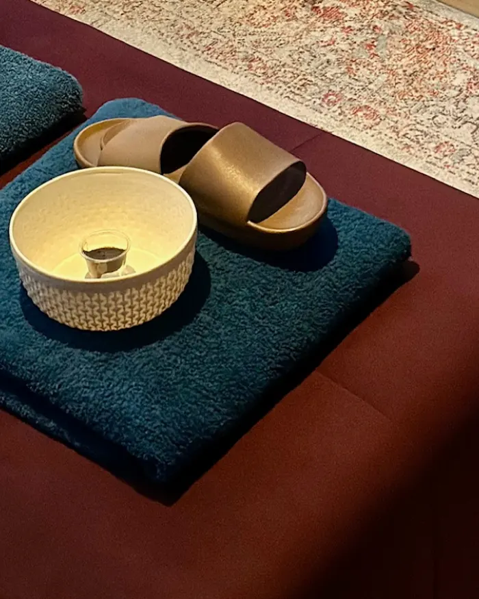 Bol de hammam, sandales et serviettes pliées